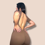 CASH SPORTWEAR brown ribbed short-sleeve jumpsuit with an open back and ruched detail on a model.