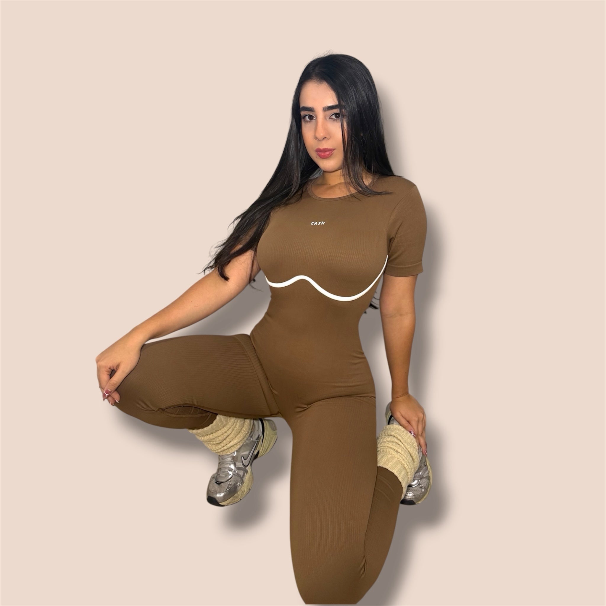CASH SPORTWEAR brown ribbed short-sleeve jumpsuit with white contrast contour detail worn by a woman with sneakers